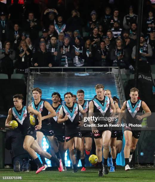 Tom Jonas of the Power leads his team out onto the oval during the 2021 AFL Round 13 match between the Port Adelaide Power and the Geelong Cats at...