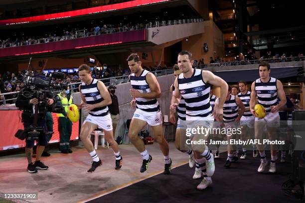 The Cats run out during the 2021 AFL Round 13 match between the Port Adelaide Power and the Geelong Cats at Adelaide Oval on June 10, 2021 in...