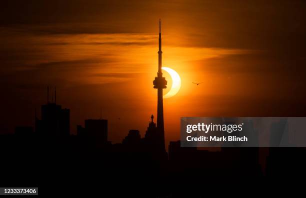 The sun rises behind the skyline during an annular eclipse on June 10, 2021 in Toronto, Canada. Across parts of Canada, viewers witnessed the rare...