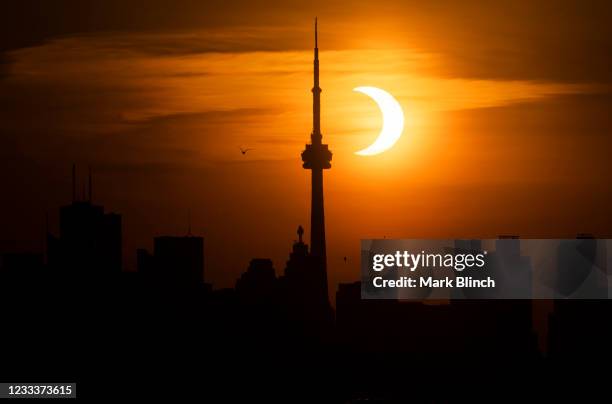 The sun rises behind the skyline during an annular eclipse on June 10, 2021 in Toronto, Canada. Across parts of Canada, viewers witnessed the rare...