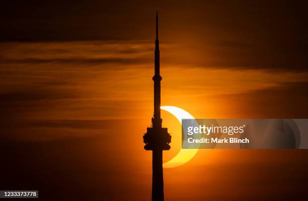 The sun rises behind the skyline during an annular eclipse on June 10, 2021 in Toronto, Canada. Across parts of Canada, viewers witnessed the rare...