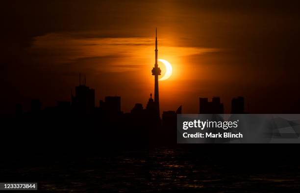 The sun rises behind the skyline during an annular eclipse on June 10, 2021 in Toronto, Canada. Across parts of Canada, viewers witnessed the rare...