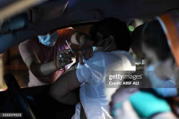 Man receives the Sinopharm vaccine against the Covid-19 , in the first drive-through vaccination centre, in Lahore on late June 10, 2021.