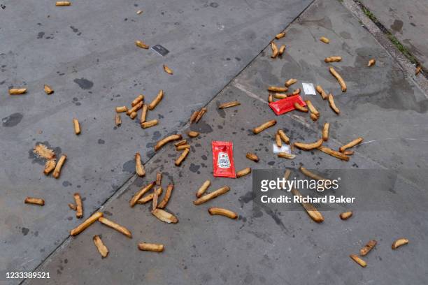 Along with sachets of salt and tomato ketchup, the remains of a portion of chips lie scattered on the pavement on London's Southbank, on 10th June...