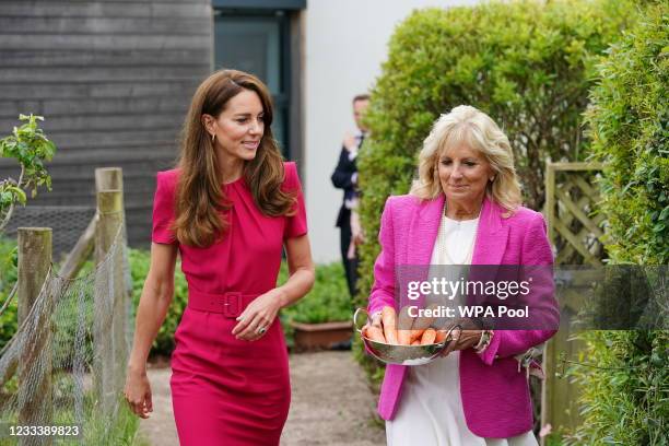 Catherine, Duchess of Cambridge and U.S. First Lady Dr Jill Biden, carrying carrots for the school rabbit, Storm, during a visit to Connor Downs...