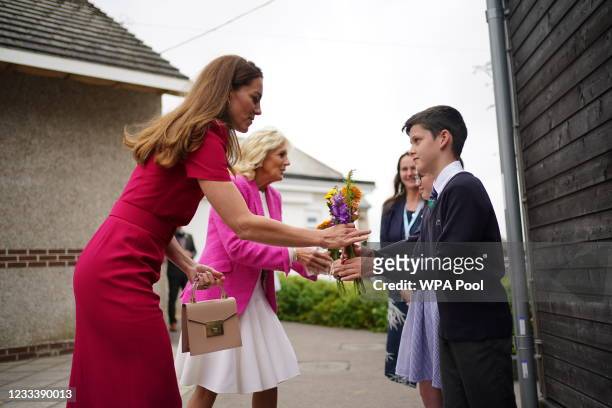 Catherine, Duchess of Cambridge and U.S. First Lady Dr Jill Biden presented with flowers by the head boy and head girl during a visit to Connor Downs...