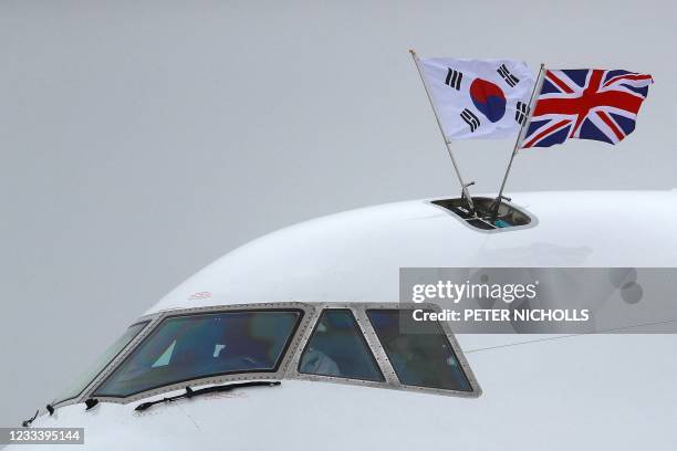 The Union and South Korean flags fly outside the presidential aeroplane as South Korea's President Moon Jae-in and South Korea's first lady Kim...