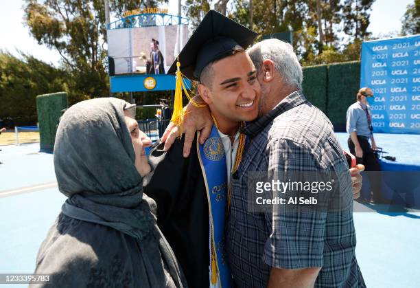 Paywand Baghal, Graduating with a degree in Dance and Biology hugs his parents Dad Abdolvahab Baghal and Mom Ommekolson Mobasheri after he walked the...