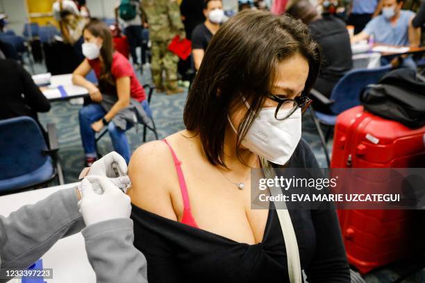 Andrea Salazar receives a dose of Johnson & Johnson vaccine against Covid-19 at Miami International Airport, in Miami, Florida, on May 29, 2021. -...
