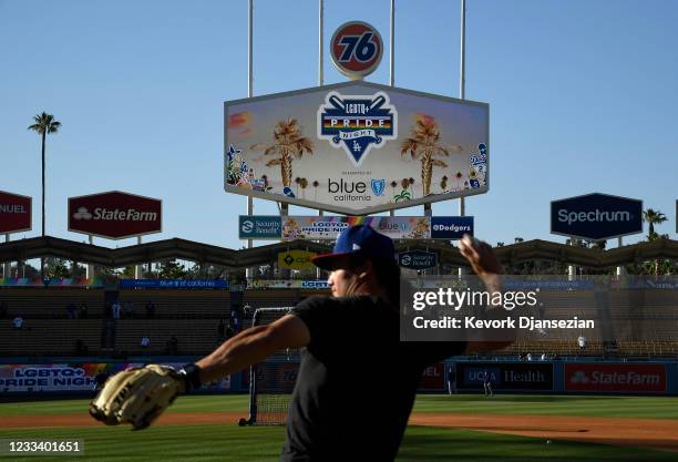 Coach Alex Burg of the Texas Rangers throws the baseball during eighth annual LGBTQ+ Night prior to start of a baseball game between the Los Angeles...