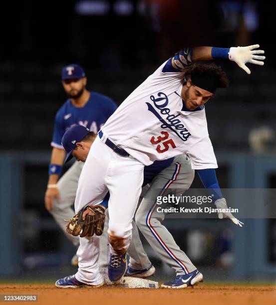 Cody Bellinger of the Los Angeles Dodgers is tagged out at second base by Nick Solak of the Texas Rangers after he tried to stretch a single into the...