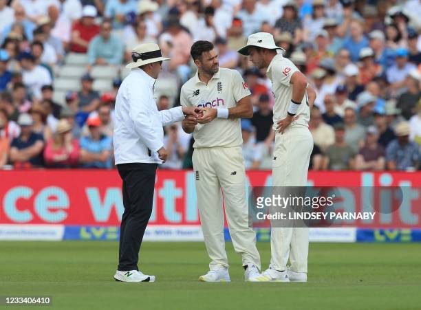 England bowlers Stuart Broad and James Anderson inspect the ball with umpire on the third day of the second Test cricket match between England and...
