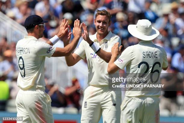 England's Stuart Broad celebrates with teammates after taking the wicket of New Zealand's Tom Blundell during play on the third day of the second...