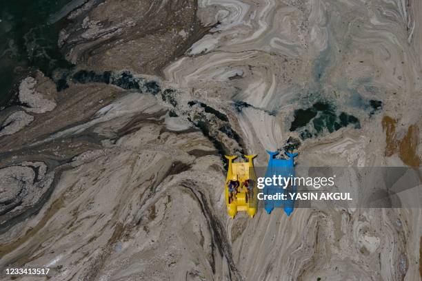 This aerial photograph taken on June 12 in the Darica district of Kocaeli, Turkey, shows pedalos sailing among the Marmara sea covered with sea snot,...