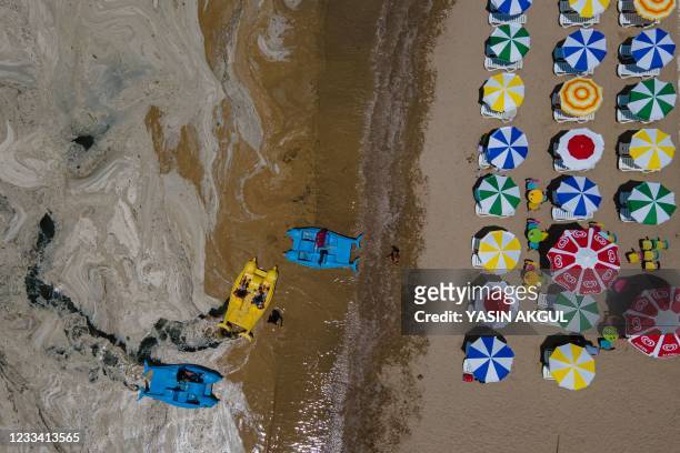 This aerial photograph taken on June 12 in the Darica district of Kocaeli, Turkey, shows pedalos on the banks of the Marmara sea covered with sea...