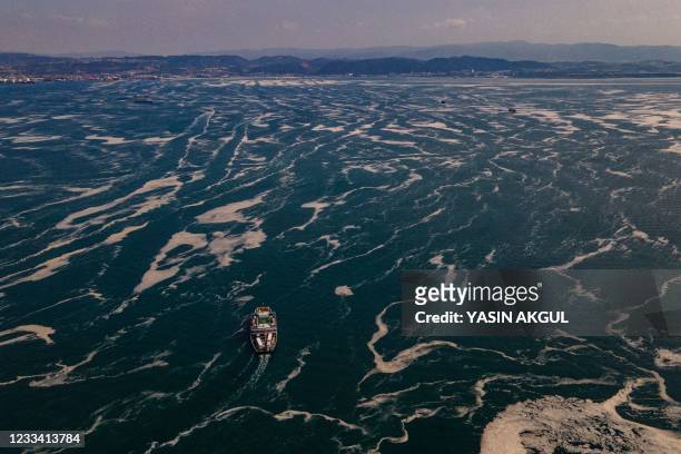 This aerial photograph taken on June 12 in the Darica district of Kocaeli, Turkey, shows boats sailing among the Marmara sea covered with sea snot, a...