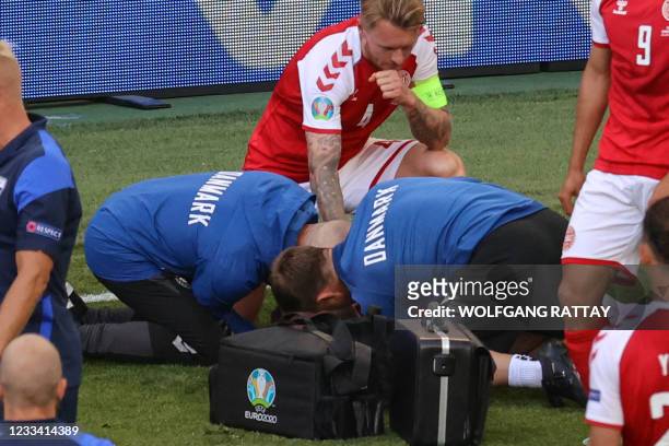 Denmark's defender Simon Kjaer observes as paramedics attend to Denmark's midfielder Christian Eriksen during the UEFA EURO 2020 Group B football...