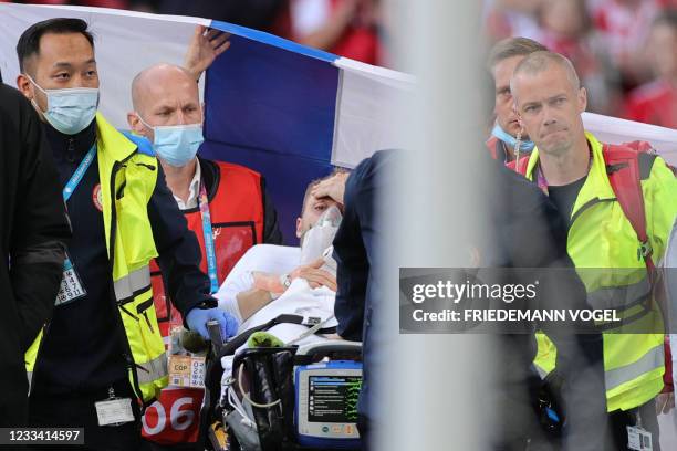 Denmark's midfielder Christian Eriksen is evacuated after collapsing on the pitch during the UEFA EURO 2020 Group B football match between Denmark...