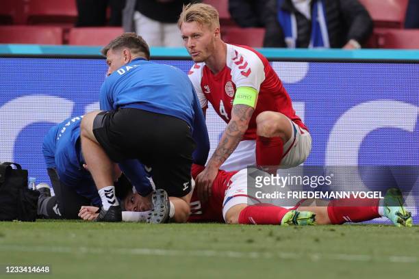 Denmark's midfielder Christian Eriksen receives medical attention after collapsing on the pitch during the UEFA EURO 2020 Group B football match...
