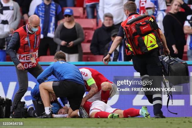 Denmark's midfielder Christian Eriksen receives medical attention after collapsing on the pitch during the UEFA EURO 2020 Group B football match...