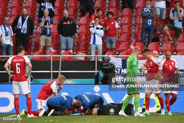 Medics attend to Denmark's midfielder Christian Eriksen after he collapsed during the UEFA EURO 2020 Group B football match between Denmark and...