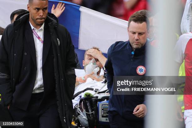 Denmark's midfielder Christian Eriksen is evacuated after collapsing on the pitch during the UEFA EURO 2020 Group B football match between Denmark...