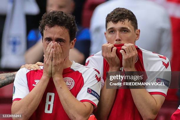 Denmark's midfielder Thomas Delaney and Denmark's defender Andreas Christensen react as paramedics attend to Denmark's midfielder Christian Eriksen...