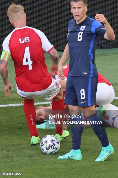 Finland's midfielder Robin Lod gestures at paramedics as Denmark's defender Simon Kjaer runs towards Denmark's midfielder Christian Eriksen after he...