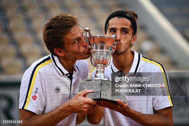 France's Nicolas Mahut and France's Pierre-Hugues Herbert kiss and celebrate with the Jacques-Brugnon Cup after winning their men's doubles final...