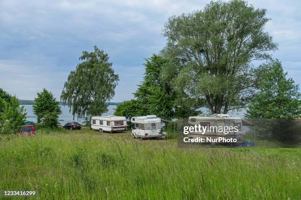 Hymer Fiat Ducato retro RV's campers, and caravans parked along the lake shore are seen at Szeroki Ostrow peninsula, Sniardwy lake, near Zdory,...