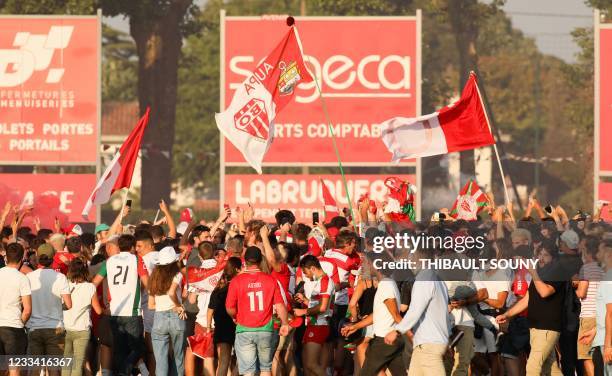 Biarritz supporters wave flags as they invade the pitch to celebrate after their team won the French Top14 rugby union playoff match against Aviron...