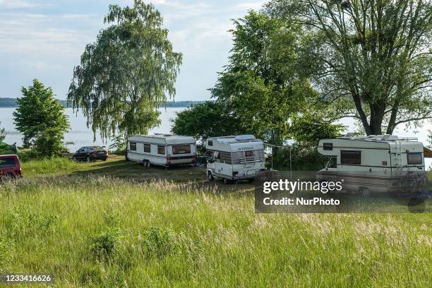 Hymer Fiat Ducato retro RV's campers, and caravans parked along the lake shore are seen at Szeroki Ostrow peninsula, Sniardwy lake, near Zdory,...