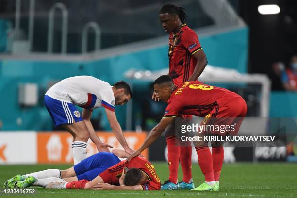 Russia's midfielder Daler Kuzyaev and Belgium's defender Timoty Castagne lie on the pitch after a collision during the UEFA EURO 2020 Group B...