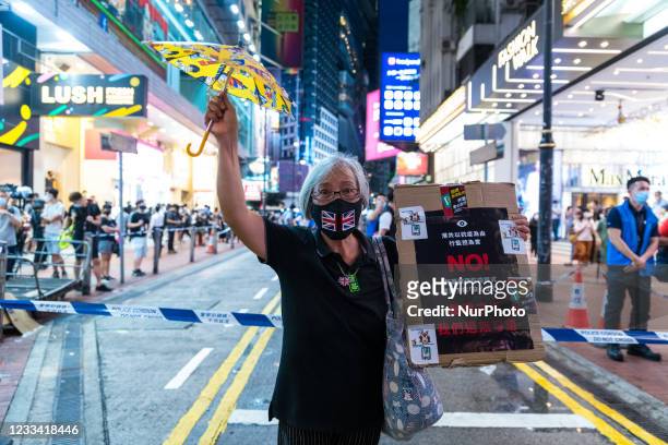 Grandma Wong stands along in Causeway Bay trying to protest by herself. Police was once again out in force in Causeway Bay and Mongkok districts in...
