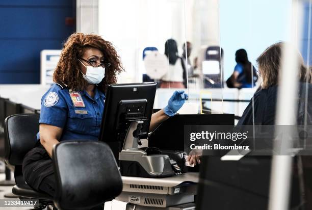 Transportation Security Administration agent screens a traveler at a checkpoint in the Detroit Metropolitan Wayne County Airport in Romulus,...