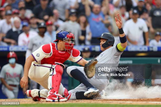 Aaron Judge of the New York Yankees scores on a single by Gary Sanchez before catcher J.T. Realmuto of the Philadelphia Phillies gets the ball during...