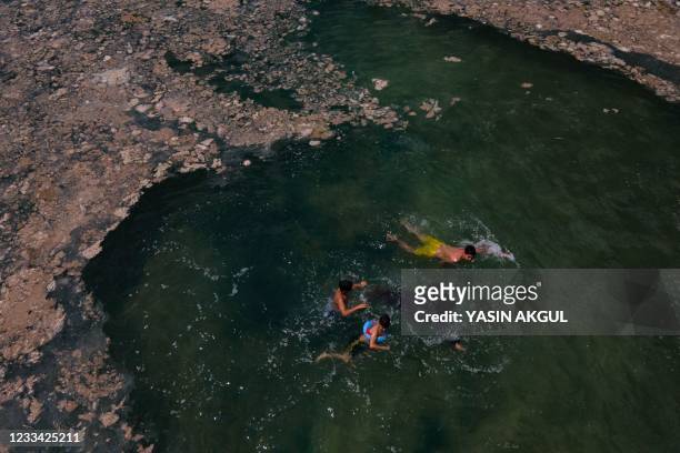 This aerial photograph taken on June 12 in the Darica district of Kocaeli, Turkey, shows children swimming in the Marmara sea covered with sea snot,...