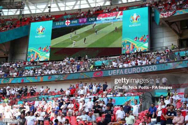 View of the big screen and fans in the stands during the UEFA Euro 2020 Group D match at Wembley Stadium, London. Picture date: Sunday June 13, 2021.