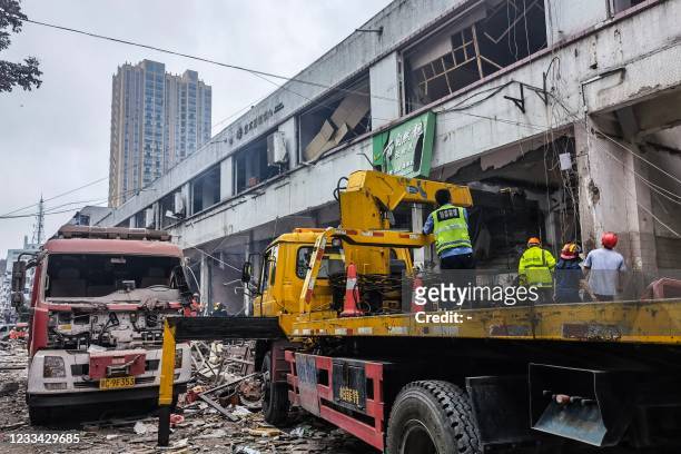 Workers search for victims in a building damaged by a gas line explosion which left at least 12 people dead and nearly 140 others injured in Shiyan,...