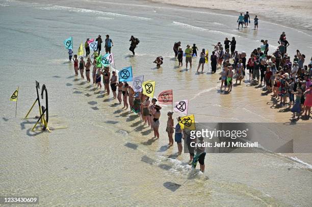 Extinction Rebellion environmental activists stage a demonstration in the harbour during the G7 summit on June 13, 2021 in St Ives, England....