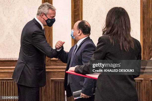 (Egypt's Finance Minister Mohamed Maait elbow-bumps France's Economy and Finance Minister Bruno Le Maire during a meeting at the prime minister's...