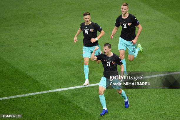 Austria's defender Stefan Lainer celebrates scoring the opening goal with his teammates during the UEFA EURO 2020 Group C football match between...