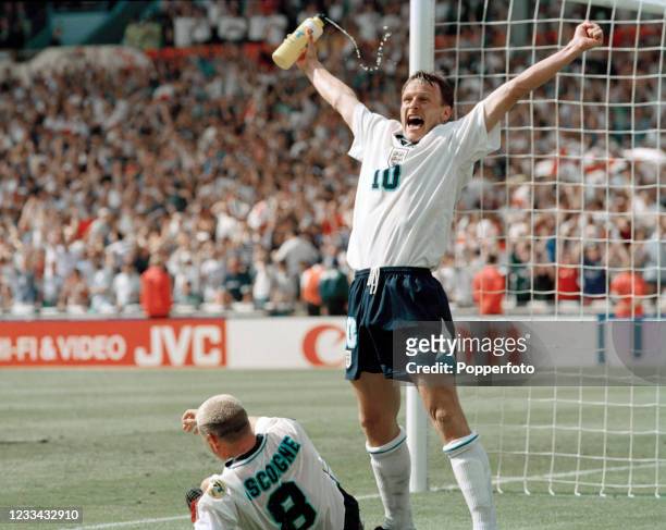 Paul Gascoigne of England gets up after celebrating with teammates including Teddy Sheringham during the UEFA Euro 1996 Group A match between...