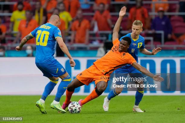 Netherlands' defender Denzel Dumfries is marked by Ukraine's defender Oleksandr Zinchenko and Ukraine's forward Oleksandr Zubkov during the UEFA EURO...