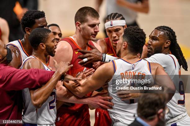 Nikola Jokic of the Denver Nuggets and Devin Booker of the Phoenix Suns exchange words after a play that would result in Jokic being ejected in the...