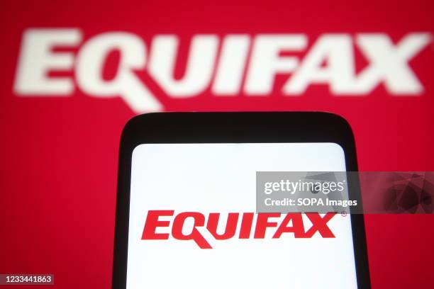 In this Photo illustration an Equifax logo is seen on a smartphone and a pc screen.