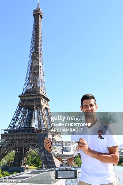 Serbia's Novak Djokovic poses with the trophy in front of the Eiffel tower, on June 14, 2021 in Paris, during a photocall one day after winning the...