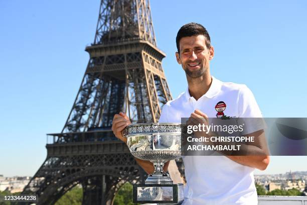 Serbia's Novak Djokovic poses with the trophy in front of the Eiffel tower, on June 14, 2021 in Paris, during a photocall one day after winning the...