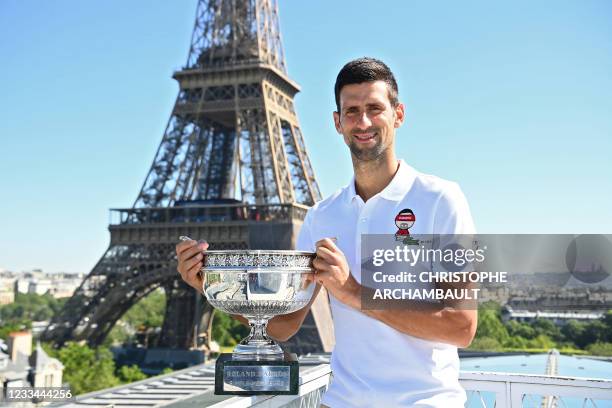 Serbia's Novak Djokovic poses with the trophy in front of the Eiffel tower, on June 14, 2021 in Paris, during a photocall one day after winning the...