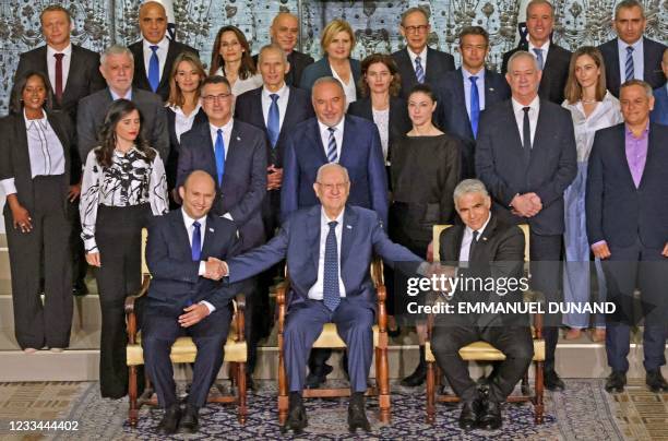 Outgoing Israeli President Reuvin Rivlin is flanked by Prime Minister Naftali Bennett and alternate Prime Minister and Foreign Minister Yair Lapid...